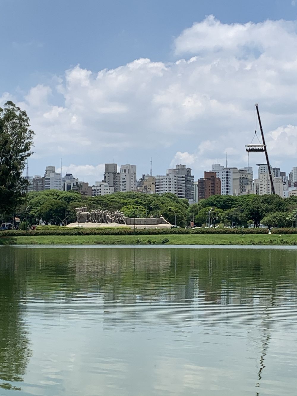 Monumento às Bandeiras visto do lago do Ibirapuera, com os edifícios residenciais do entorno de Moema atrás