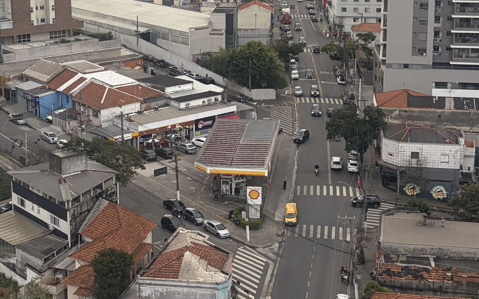 Rua comercial do bairro Saúde vista do alto, com casas térreas, comércio de esquina e prédios residenciais novos e antigos ao redor