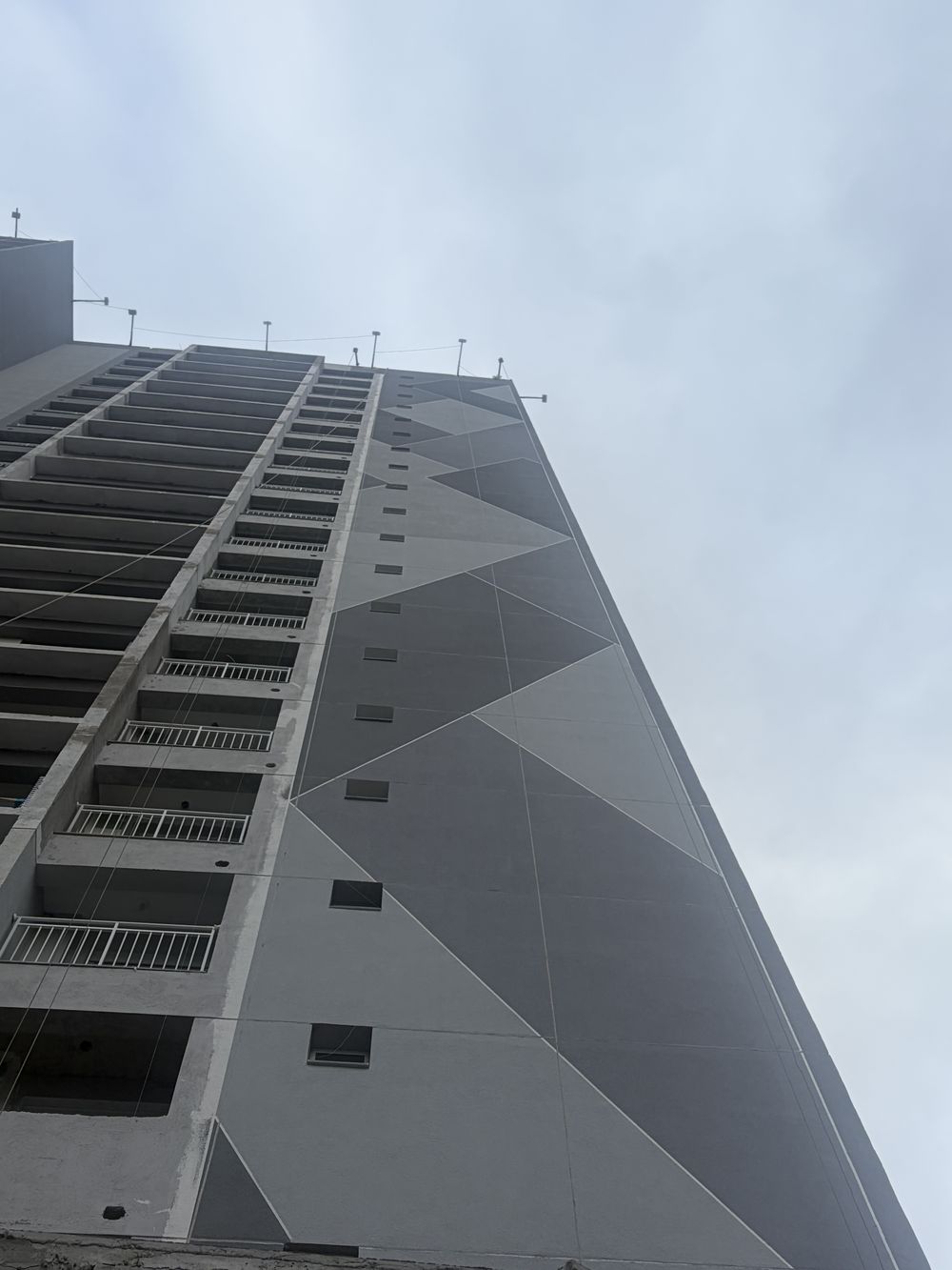 Fachada geométrica em tons de cinza de um edifício residencial novo na região da Saúde, vista de baixo para cima